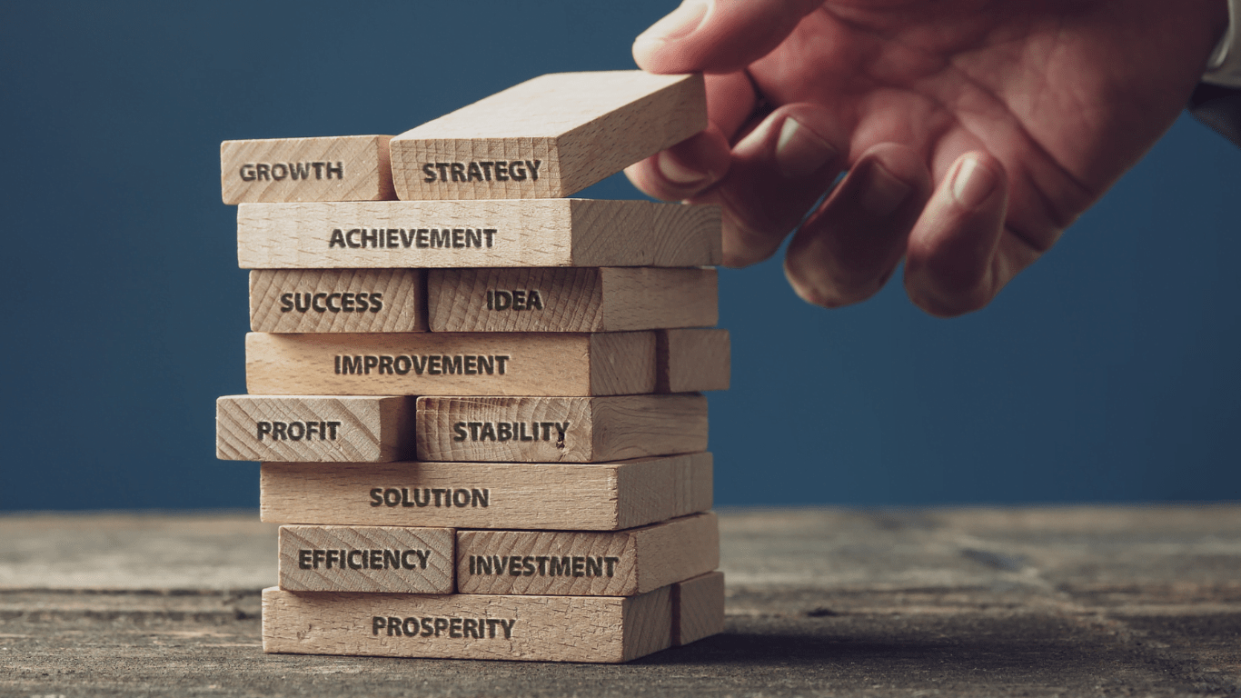 hand stacking blocks with words relating to small business development